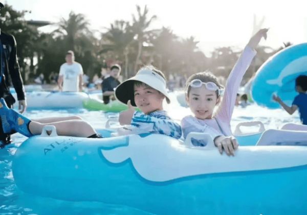 小酒窝和朵朵坐充气艇，笑容灿烂。