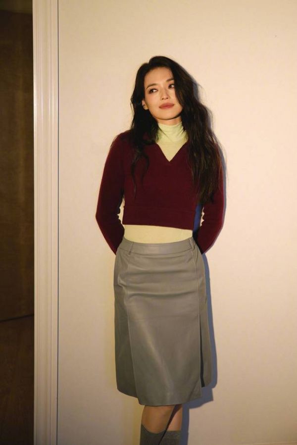 舒淇在暖光墙前侧头凝望，尽显温柔又复古的气质。