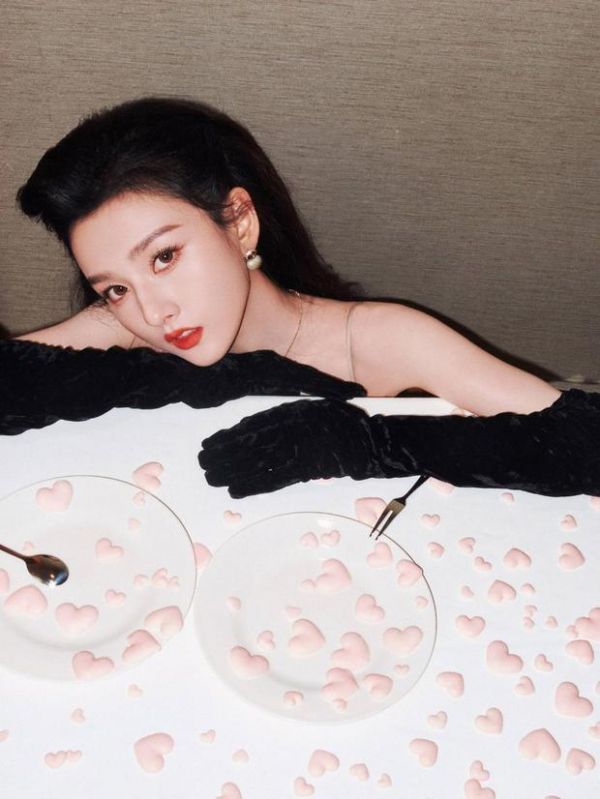 宋祖儿在满桌爱心甜点旁侧头凝望，尽显慵懒又精致的氛围。