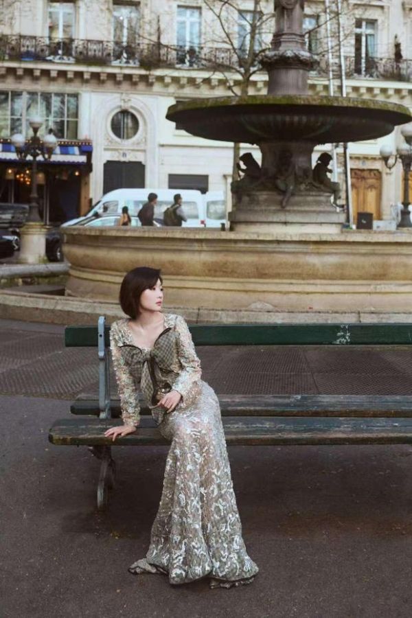 周冬雨坐喷泉长椅，沉静温柔。