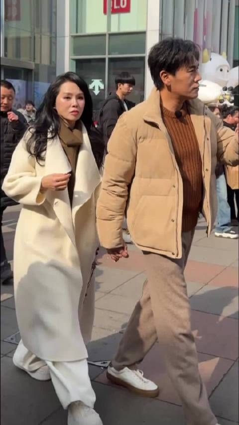 没想到明星穿衣服也不剪吊牌，伊能静穿大衣和秦昊旅游，吊牌一晃一晃好抢眼