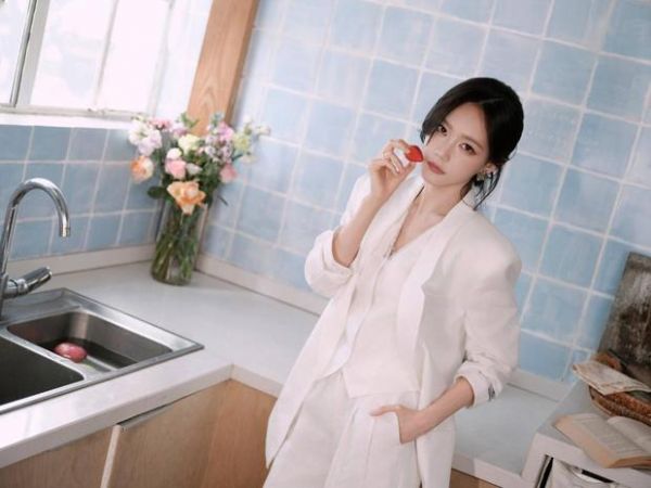 李一桐拈草莓近脸，眼神灵动娇俏。