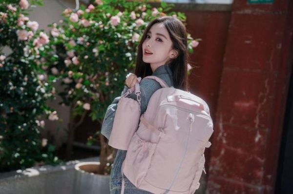 娜扎拎包侧身,花前拍摄清新灵动。