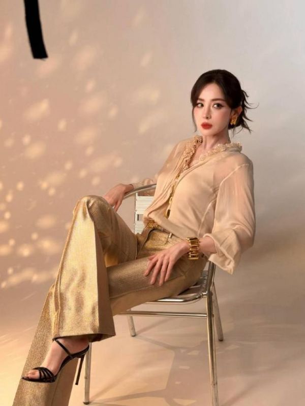 搜狐娱乐讯 22日，古力娜扎拍摄的最新造型花絮照曝光，她身穿蕾丝领上衣搭配金色长裤优雅迷人，五官精致明艳似美神降临！