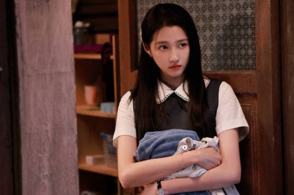 关晓彤手里抱着衣服。