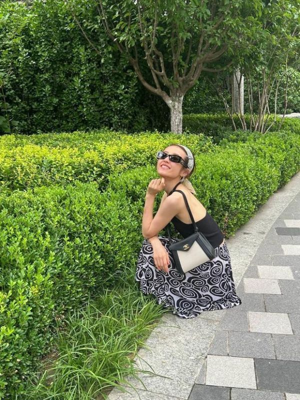 张子枫蹲在地上拍照,笑容满面,松弛感拉满。