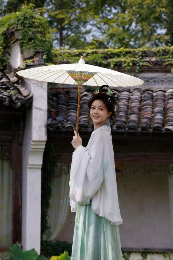 搜狐娱乐讯 近日，赵今麦一组古装江南片场花絮释出，她身穿淡青古风长裙执油纸伞漫步水乡庭院，青衣袅袅步履轻盈，一颦一笑间尽显温婉东方韵味。