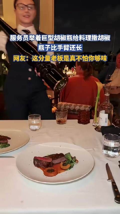 服务员举着巨型胡椒瓶给牛排撒胡椒，瓶子比手臂还长