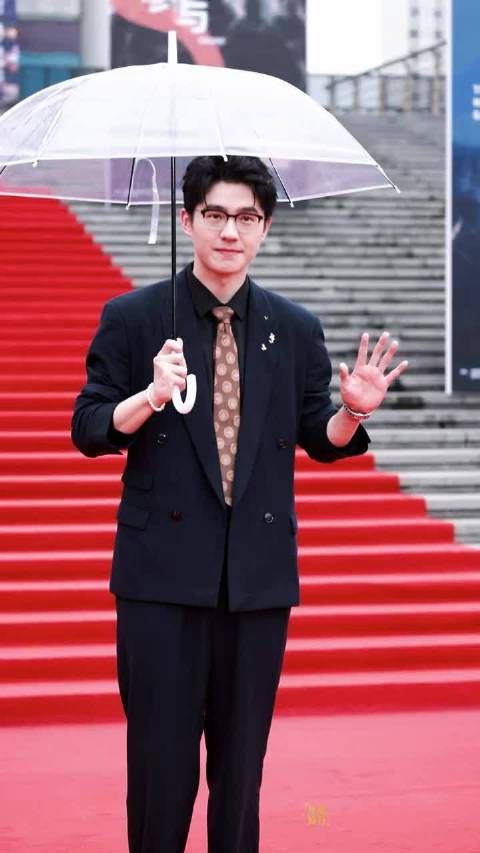 刘昊然雨天撑伞，黑西装内敛稳重气质渐显