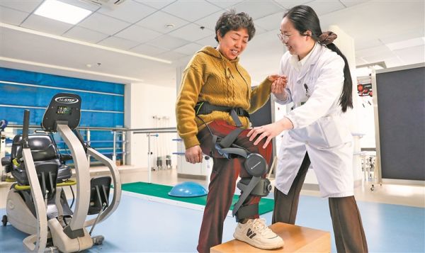 患者在治疗师指导下穿戴外骨骼机器人进行康复训练。 新华社发(顾彬斌摄)